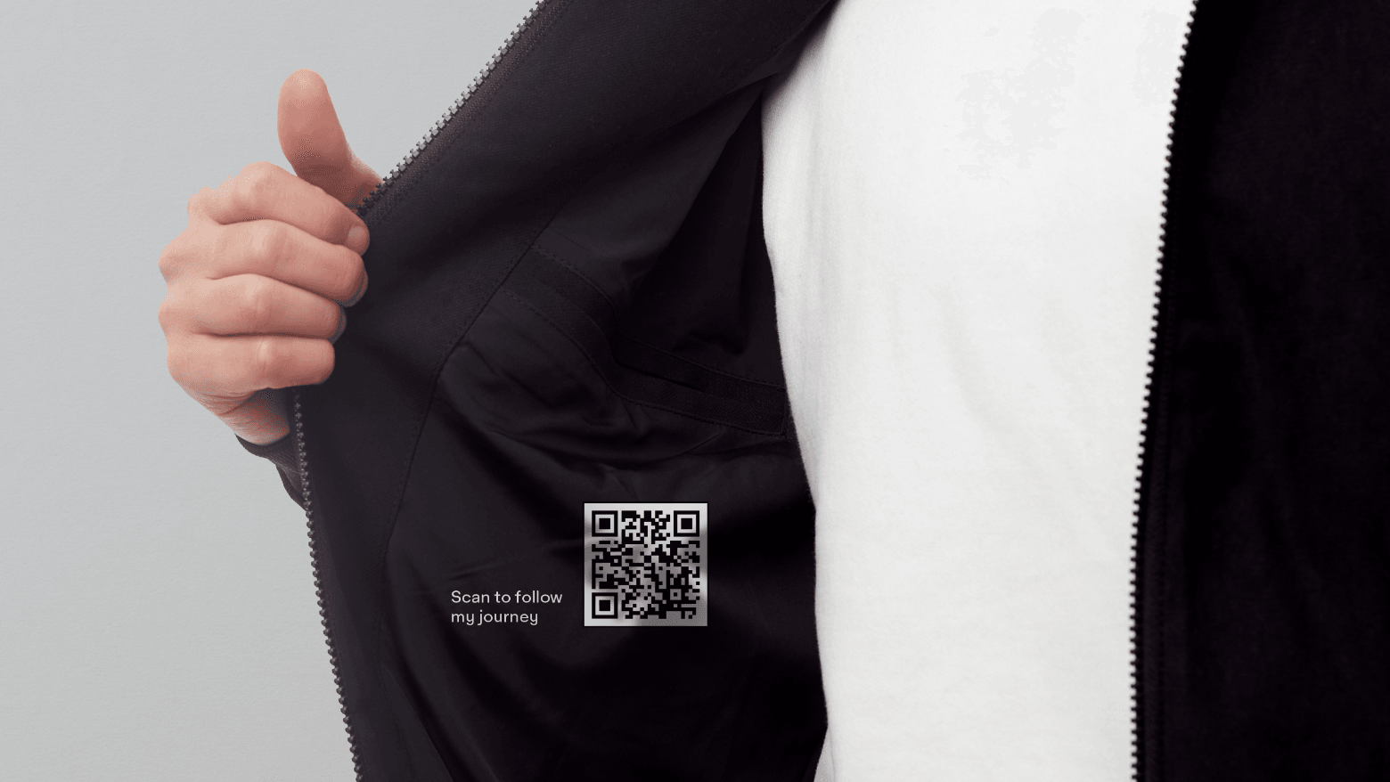 man holding open a jacket to show a qr code